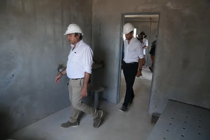 El gobernador Maximiliano Pullaro observa el interior de una de las nuevas celdas individuales de hormig&oacute;n premoldeado en el penal El Infierno.