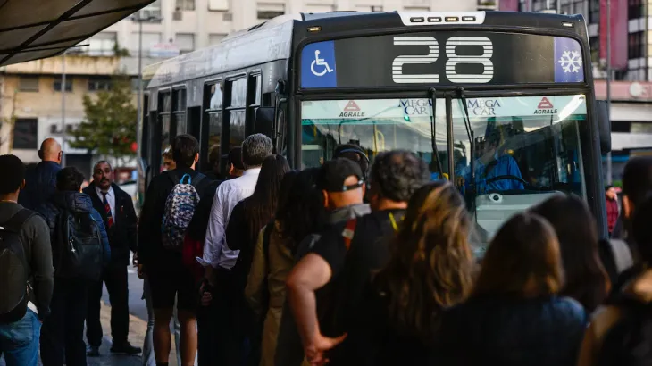 Fila de personas esperando el colectivo en la Ciudad de Buenos Aires.