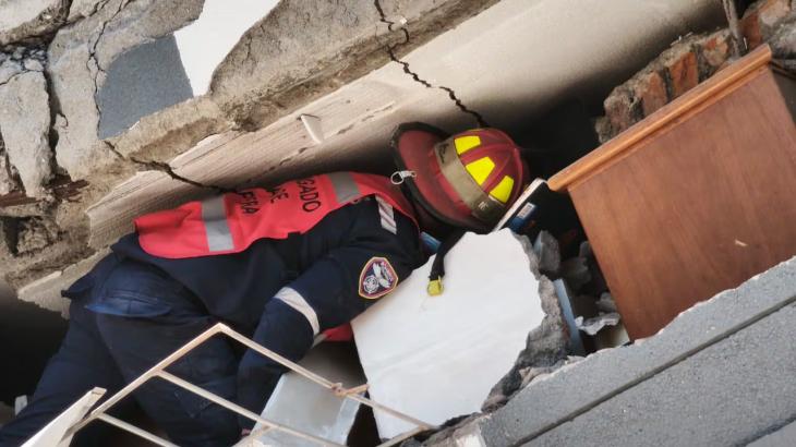 Un bombero busca v&iacute;ctimas entre dos losas de concreto. Argentina eval&uacute;a enviar brigadistas de b&uacute;squeda y rescate, como los que despleg&oacute; en Venezuela hace seis semanas.