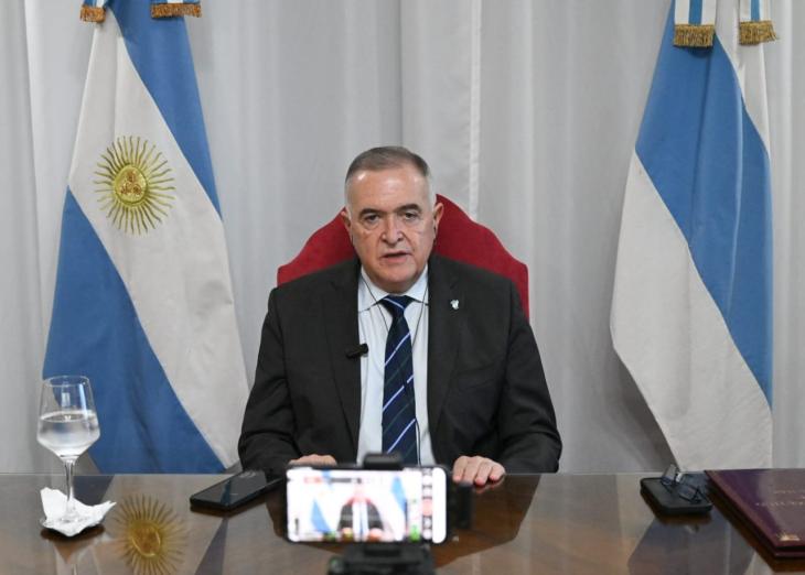 Osvaldo Jaldo sentado ante un escritorio frente a un celular grabando.
