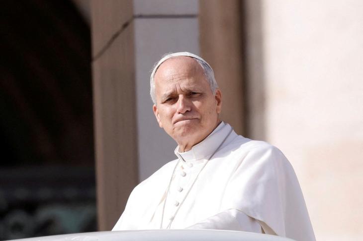 El Papa León XIV observando a cámara, con rostro serio, frente al Vaticano.