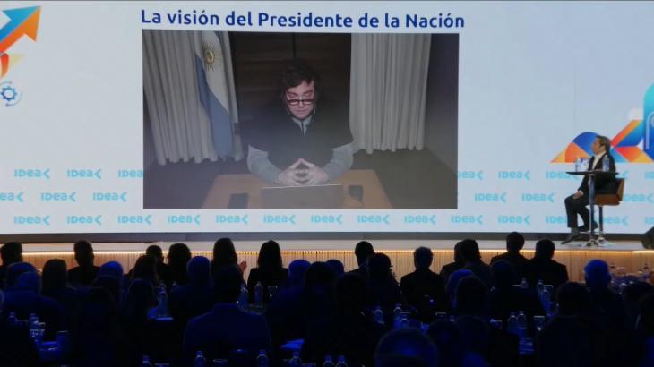 Escenario del 62° Coloquio de IDEA en el Hotel Sheraton de Mar del Plata, con el periodista José Del Río y Javier Milei en pantalla por videollamada desde París.