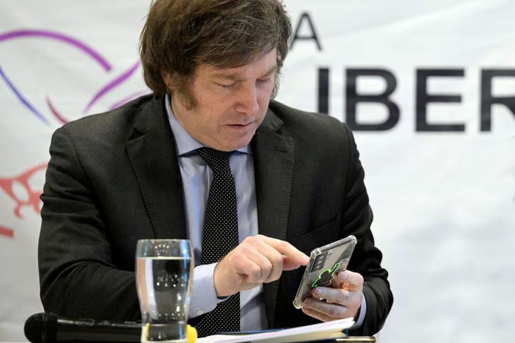 Javier Milei mira su teléfono celular